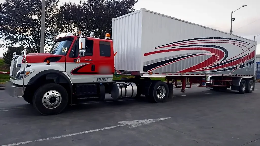 Tractomula International blanca y roja de Transportes J&L SAS con contenedor