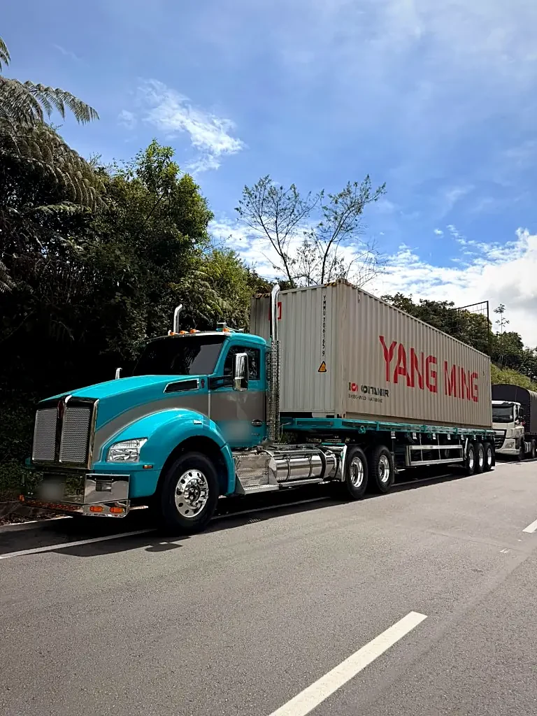 Tractomula Kenworth turquesa con contenedor Yang Ming